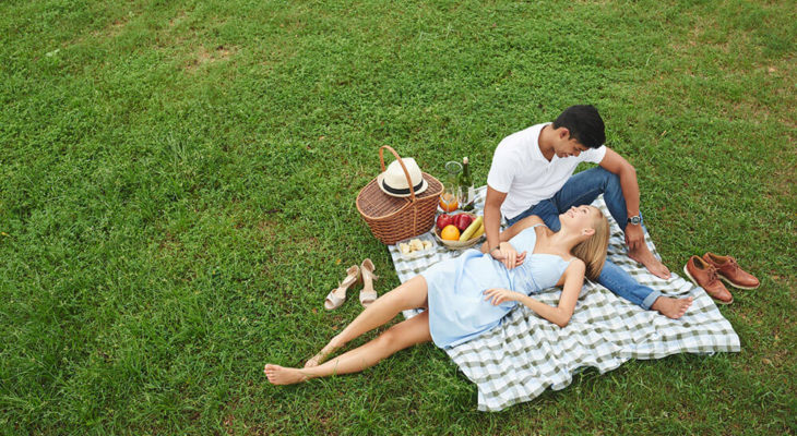 Young happy couple enjoying picnic in park
