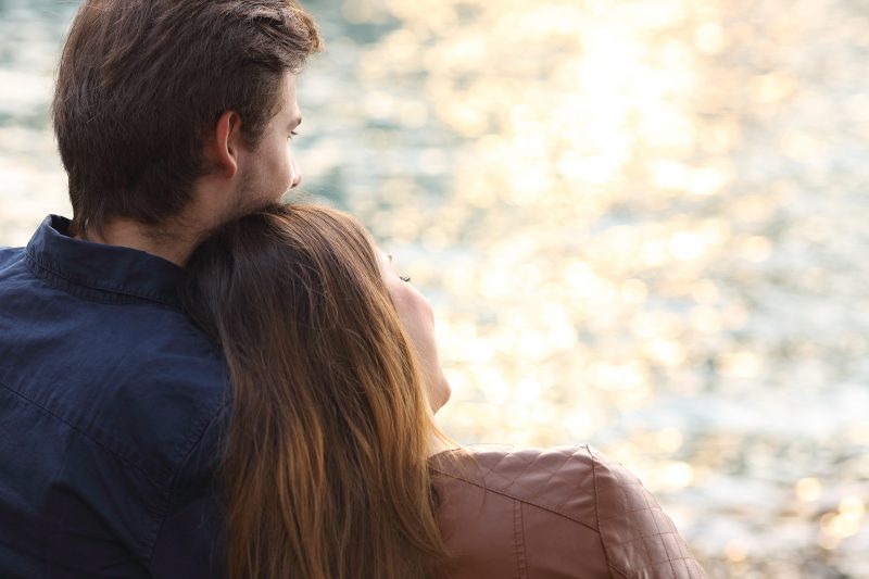 Happy couple taking in the sunset views on their romantic getaway