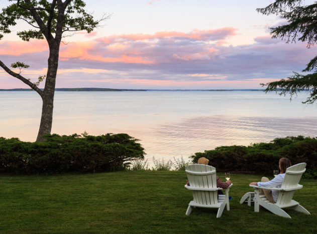 Couple in Adirondack chairs relaxing with wine